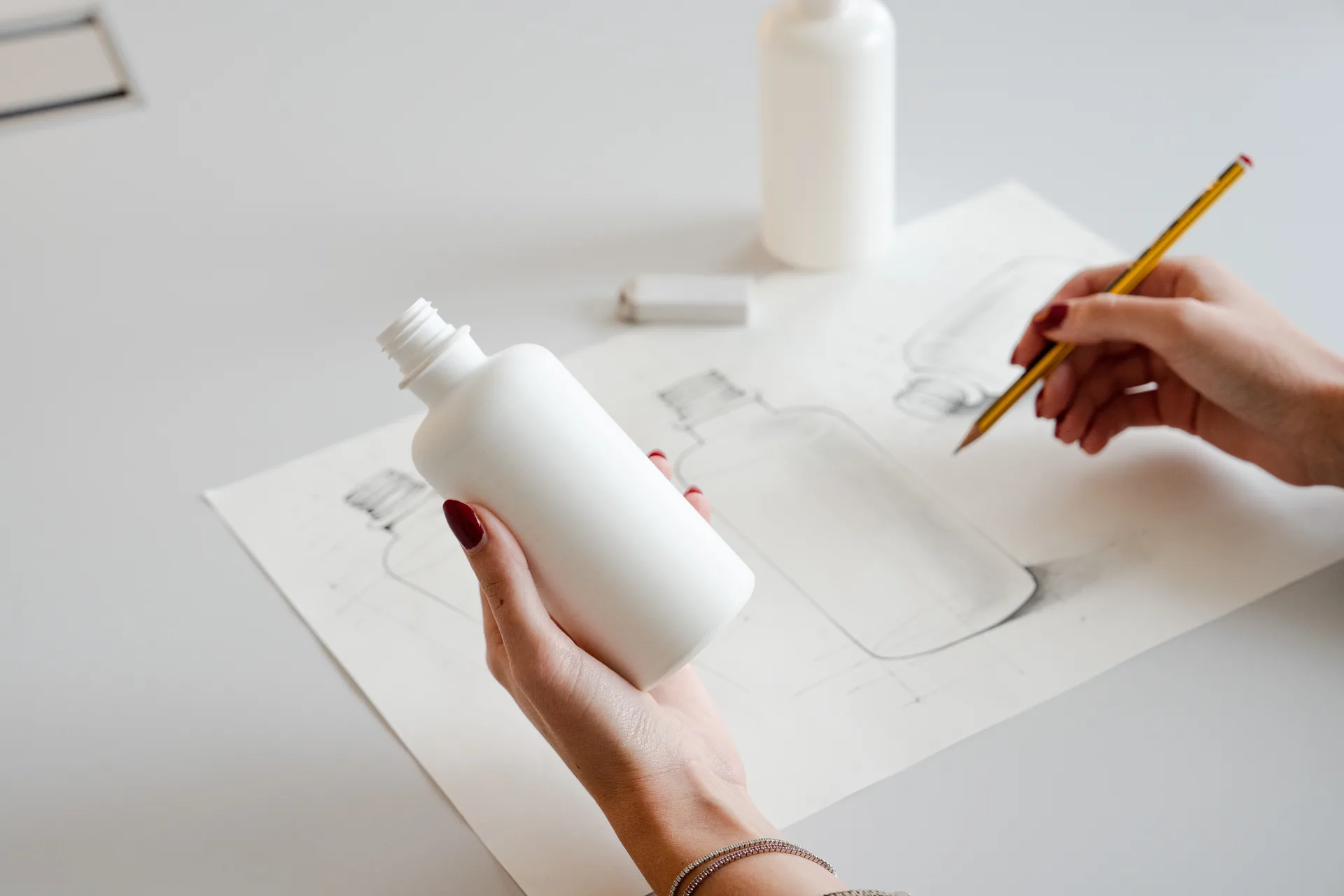 Disegno tecnico di un flacone accanto al campione realizzato