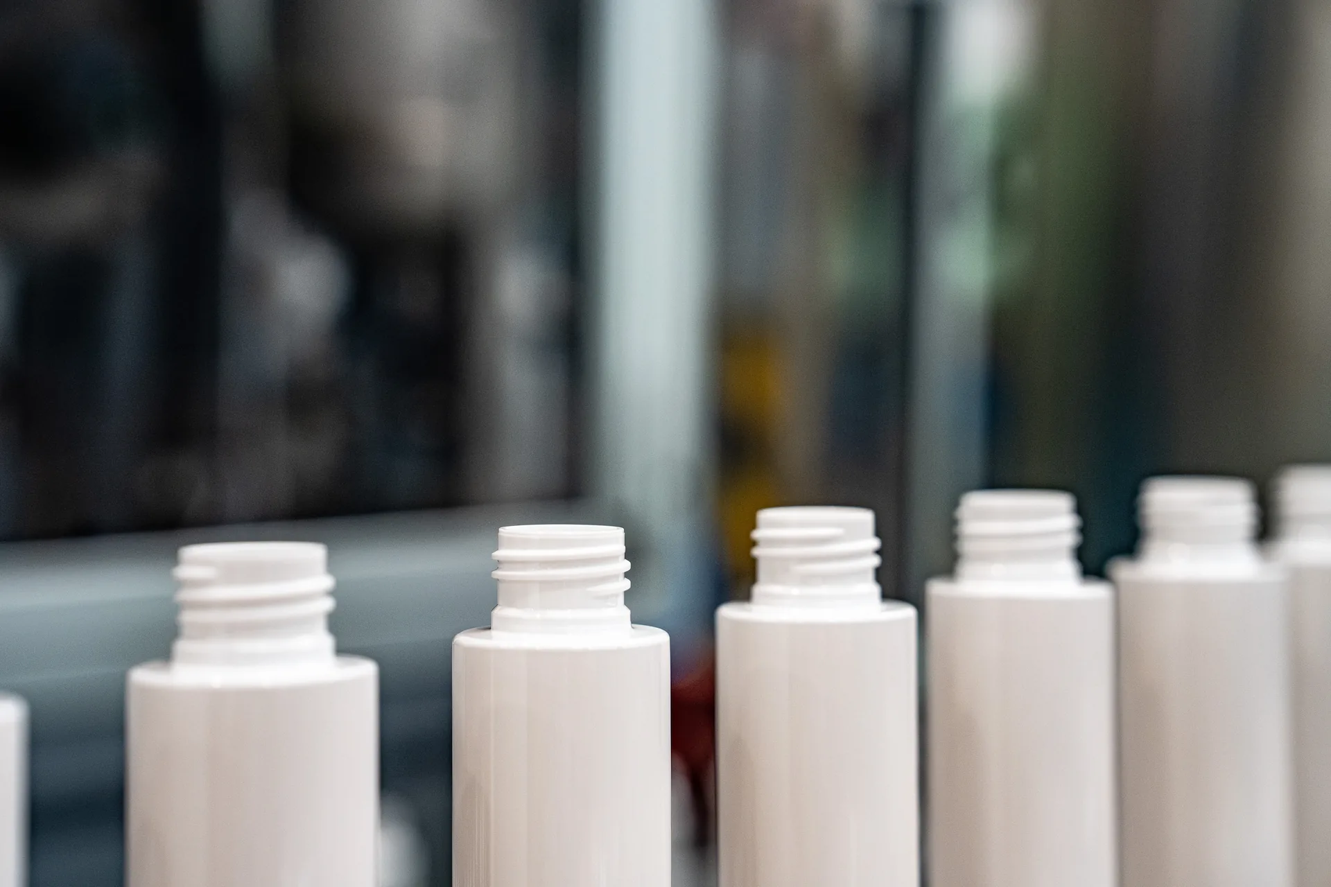 Flaconi in plastica allineati sulla linea di produzione