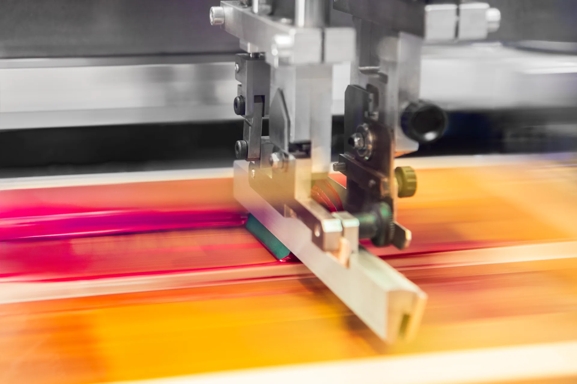 Macchina serigrafica in funzione con inchiostri a registro