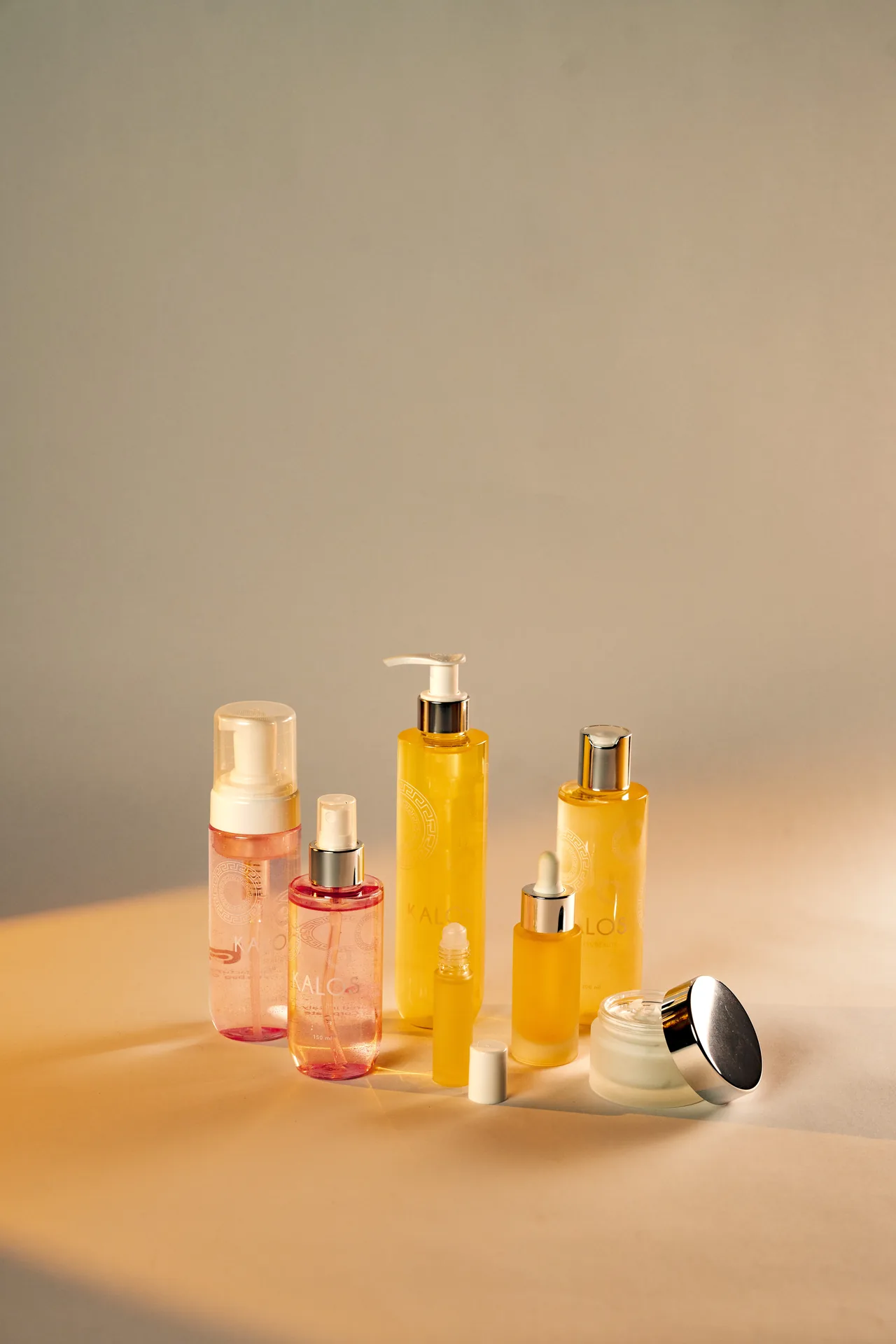 Linea skincare Ho.Bag: foamer e spray in plastica rosa, flaconi e dropper in vetro giallo, roll-on e vaso con capsula argento